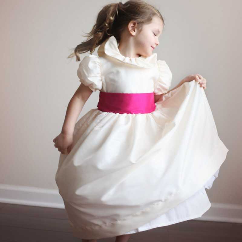 Daphné ivory designer flower girl dress with frill collar and puff sleeves  and fuschia sash by UK designer Little Eglantine