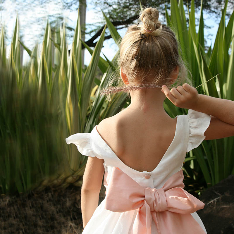 Felicity off white linen flower girl dress with deep romantic back and knee-length skirt for an elegant wedding by Little Eglantine