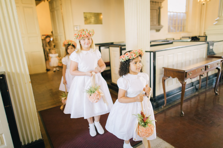 Flower girls entering the chuch wearing Little Eglantine dresses in white dress and silver sash